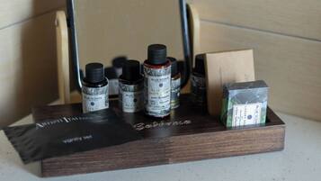 A wooden shelf with various bottles and a mirror.