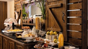 A buffet with various food items and a beverage dispenser. - Vathyskia Guesthouse (Xylokastro-Evrostina)