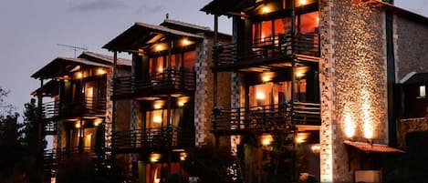 A multi-story building with balconies and warm lighting.