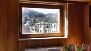 Ein Fenster mit Blick auf ein Gebäude mit einer Kuppel und Bäumen.