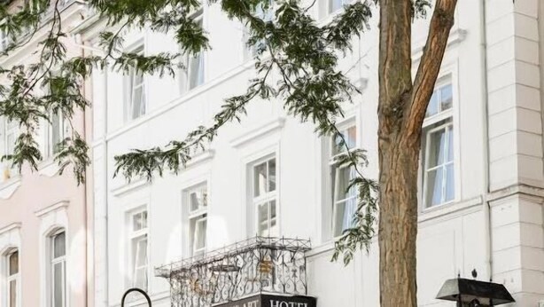 Ein Hotel mit einem Schild, auf dem 'HOTEL WEISSES HAUS ART' steht.