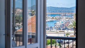 A marina with boats, a parking area, and a view of the coastline. - algherohorizon (Alghero)