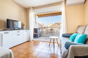 Een modern appartement met keuken, eethoek en balkon met uitzicht over de stad.