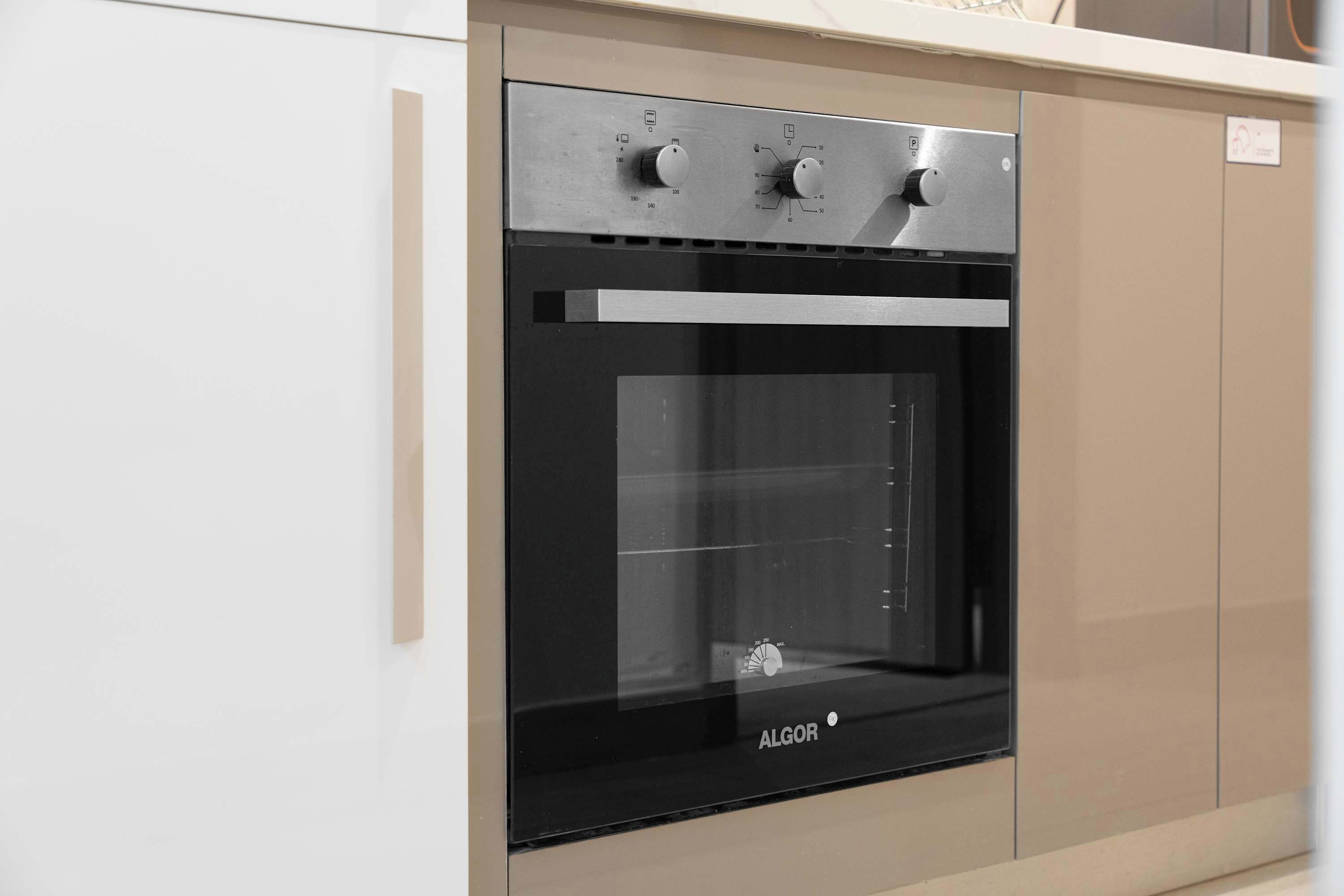 A modern kitchen with a built-in oven, stainless steel appliances, and a minimalist design.