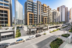 A modern urban hotel with multiple high-rise buildings, a rooftop garden, and a street view with cars. - Free housekeeping visits during your stay - Peaceful Studio for 2 in Meydan! (Meydan)