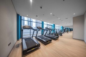A gym with treadmills, exercise equipment, and large windows. - Free housekeeping visits during your stay - Peaceful Studio for 2 in Meydan! (Meydan)