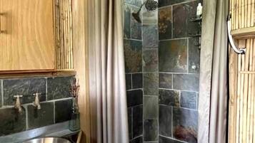 A bathroom with a shower, a sink, and a toilet.