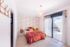 A bedroom with a bed, a window, and a view of the outside. - Villa Macatia - 200m from the beach (Saint-Paul)
