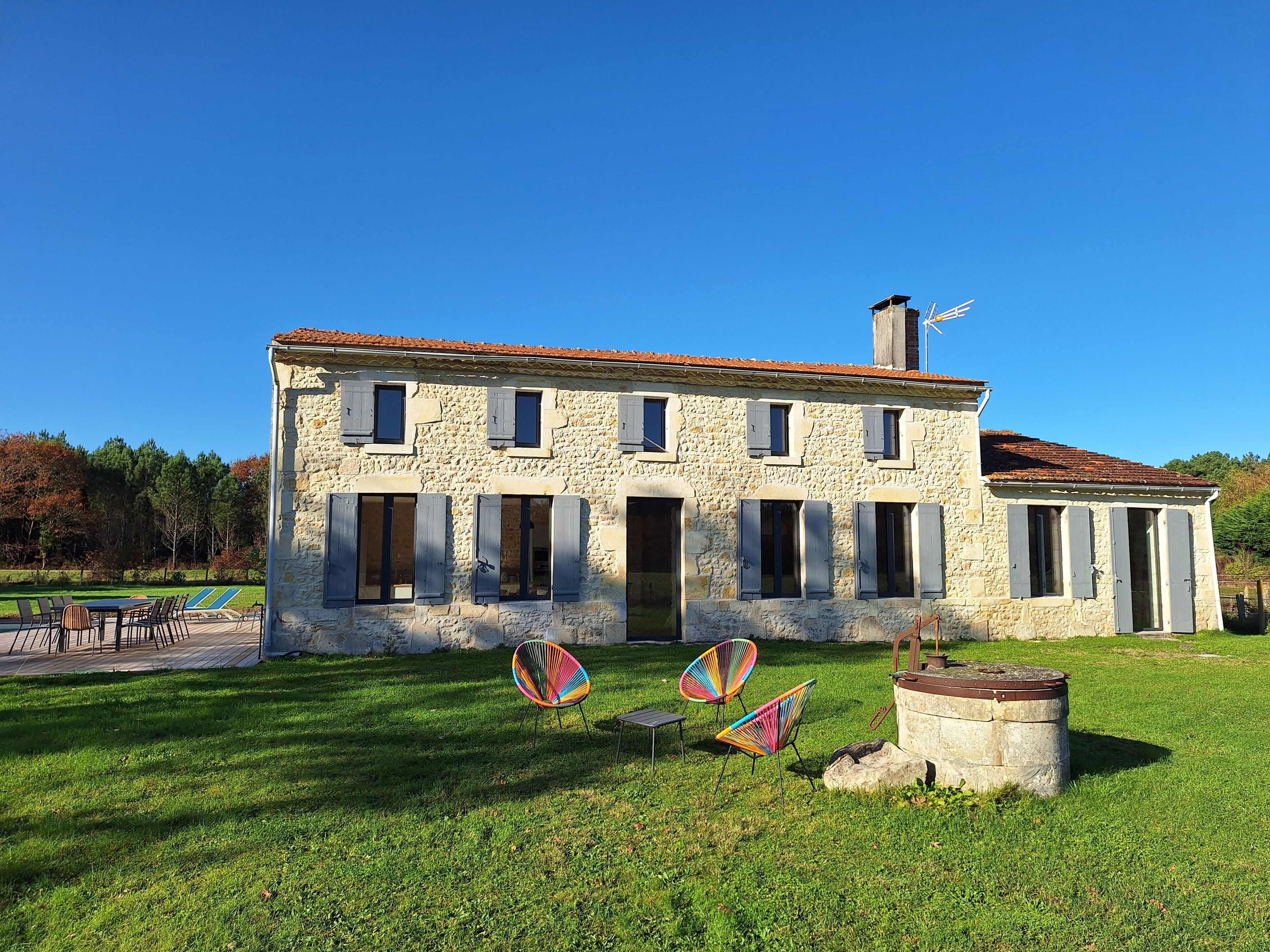 A stone building with multiple windows and a chimney.