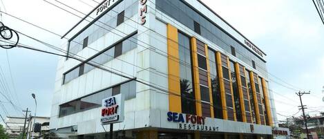 A multi-story building with signage for 'Sea Fort Restaurant' and 'Fort Malabar Rooms.'