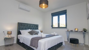 A bedroom with a bed, bedside lamps, a window, and a small table with a plant. - Villa Dani by Villas Guide (Gostinjac)