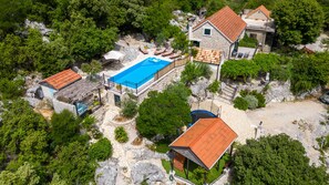 An aerial view of a property with a swimming pool, stone buildings, and lush greenery. - Rural house Janjic by Villas Guide (Plina Jezero)