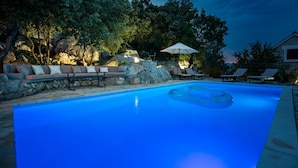 Una piscina con sillas de descanso y una zona de estar.