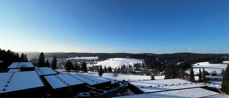 A snow-covered landscape with buildings and a wind turbine.
