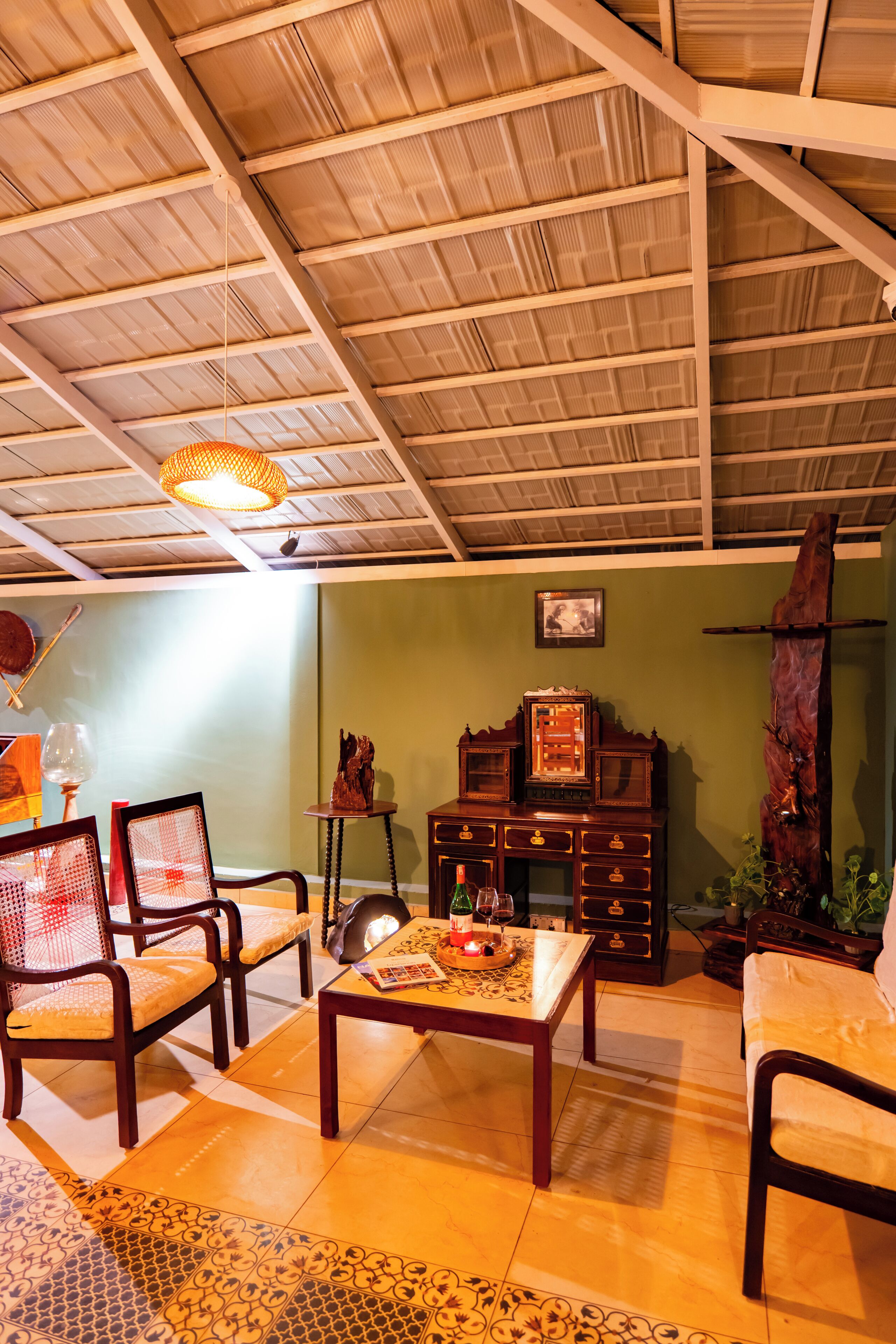 Una habitación con techo alto, muebles de madera, una alfombra estampada y un mueble de pared.