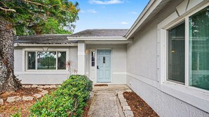 A residential house with a front door, a window, and a small garden area.