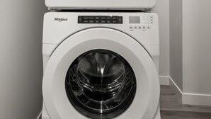A stacked washer and dryer unit in a laundry room. - Lux Downtown Urban Escape W/ Gym & 2 Free Parking (Calgary)