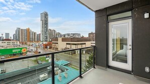 A balcony with a city view, a door, and a glass railing. - Luxe Downtown Getaway W / 2 Free Parking! (Calgary)