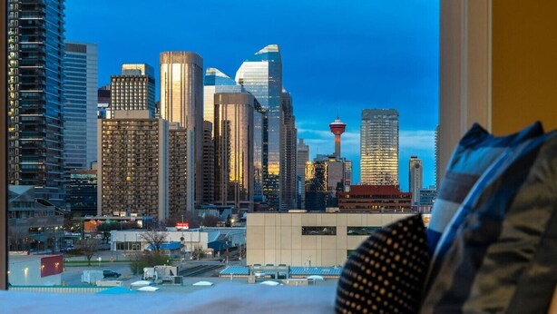 A hotel room with a cityscape view, including high-rise buildings and a tower. - Luxe Downtown Getaway W / 2 Free Parking! (Calgary)