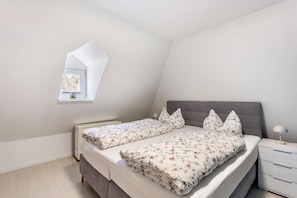 A bedroom with a bed, bedside table, and a window. - Apartment “Ferienwohnung Forsthaus Bigge” with Wi-Fi (Olsberg)