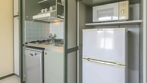 A compact kitchen with a dishwasher, a microwave, and a refrigerator. - Residence Hotel Club House (Cattolica)