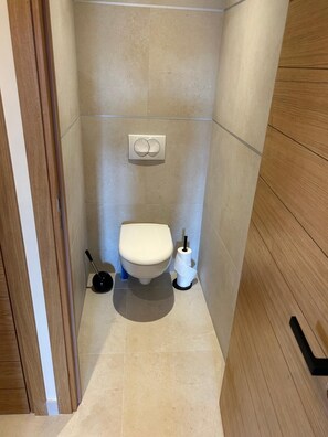 A small, modern bathroom with a toilet, bidet, and toilet paper holder. - Luxury apartment on the port of Bonifacio (Bonifacio)