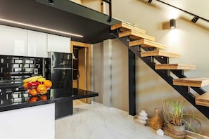 A modern kitchen with a black countertop, a built-in refrigerator, and a fruit bowl. - Chrysma Urban Living 1, Apartment (Rhodes)