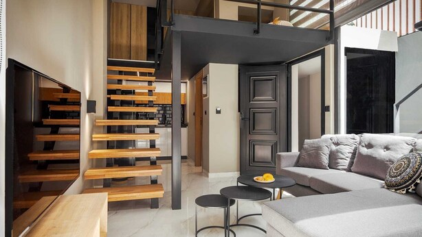 Een modern interieur met een trap, een bank en een kleine ronde tafel.