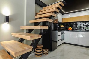 Una cocina moderna con un refrigerador negro, un microondas y un salpicadero de azulejos negros.