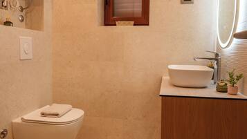 A bathroom with a toilet, sink, and mirror.