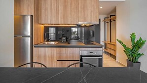 Eine moderne Küche mit Holzausstattung, Edelstahlgeräten und einer schwarzen Arbeitsplatte.