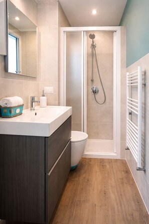 Ein modernes Badezimmer mit Dusche, Toilette und Waschtisch.