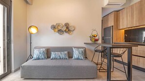 Een moderne woonkamer met een grijze bank, een vloerlamp en een kunstwerk aan de muur.