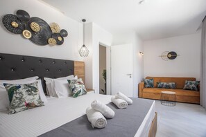 A modern bedroom with a bed, a sofa, and a wall art piece. - Calma Luxury Villa (T), Villa (Rhodes)