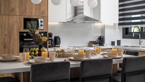 Une cuisine moderne avec un coin repas, comprenant un îlot central avec des produits pour le petit-déjeuner, un four à micro-ondes et une machine à café.