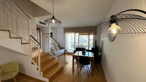 Ein modernes Interieur mit Treppe, Essbereich und großem Fenster.