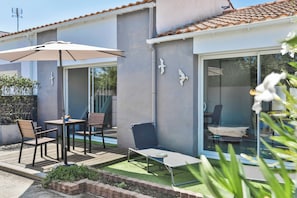 A patio with a table, chairs, and a lounge chair. - La tranquillité bleue - 4* with SPA and parking lot (Les Sables-d'Olonne)