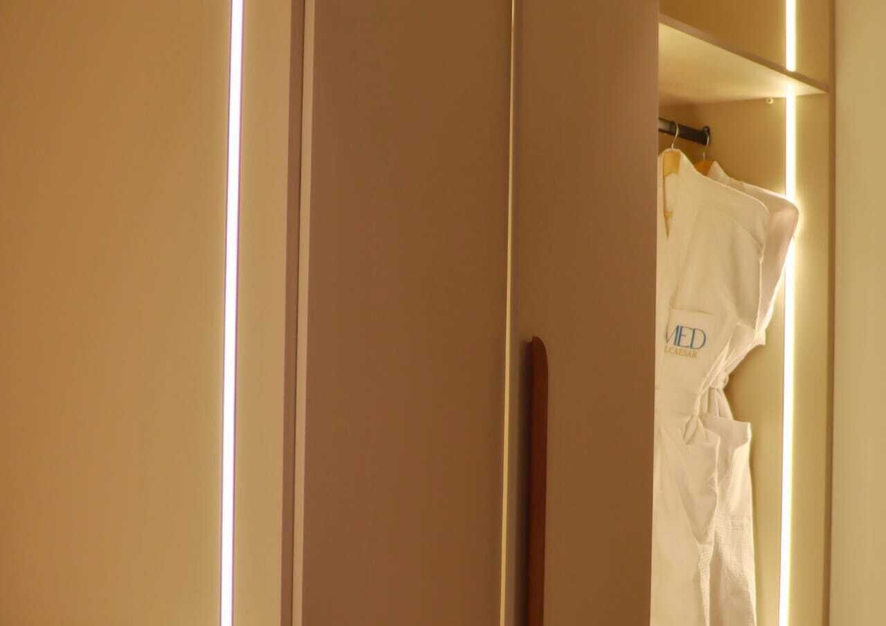 A room with a closed door, a wooden handle, and a white robe hanging on a rack.