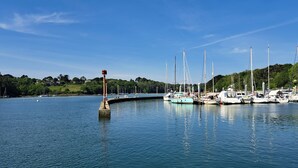 Een jachthaven met aangemeerde boten, rustig water en een heldere lucht.
