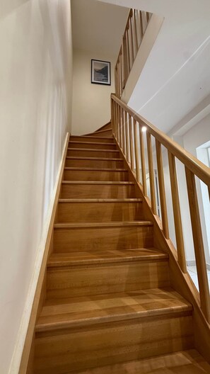 A wooden staircase with a handrail, leading to an upper floor. - Elegant family home 10 Pers /RER D /Parc Astérix /CDG (Goussainville)