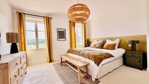 A bedroom with a bed, bedside tables, a bench, a dresser, and a large window with curtains. - 6 bedroom villa completely renovated in 2026 located between sea and countryside ✨ (Ramatuelle)