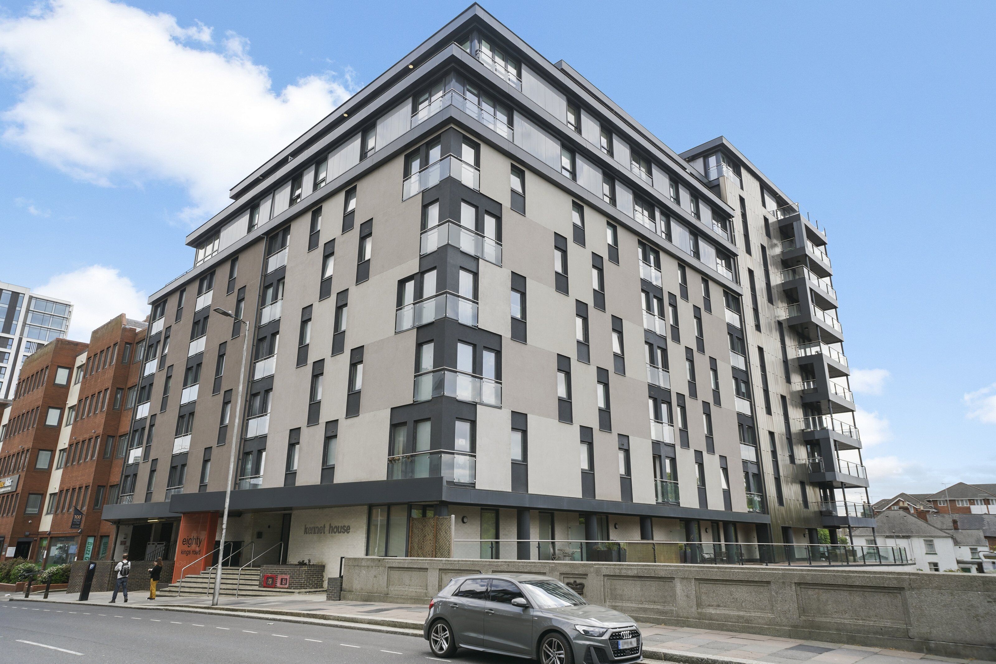 A multi-story building with a modern architectural design, featuring a mix of balconies and windows.