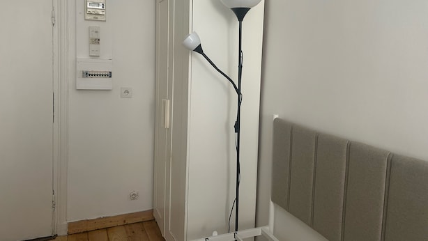 A room with a white door, electrical panel, floor lamp, and a headboard. - La Folie Urban Room R Publique Marais Canal St Martin (Paris)