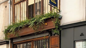 A building with a wooden facade, large windows, and a sign indicating a studio. - La Folie Urban Room R Publique Marais Canal St Martin (Paris)