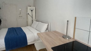 A room with a bed, a bedside table, a lamp, and a wall-mounted radiator. - La Folie Urban Room R Publique Marais Canal St Martin (Paris)