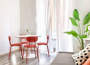 A room with a round table, four red chairs, a potted plant, and a polka-dotted pillow. - DaliTourism - Colosseum Experience 28 (Roma)