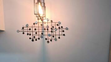 A dining table with a modern pendant light fixture above it.