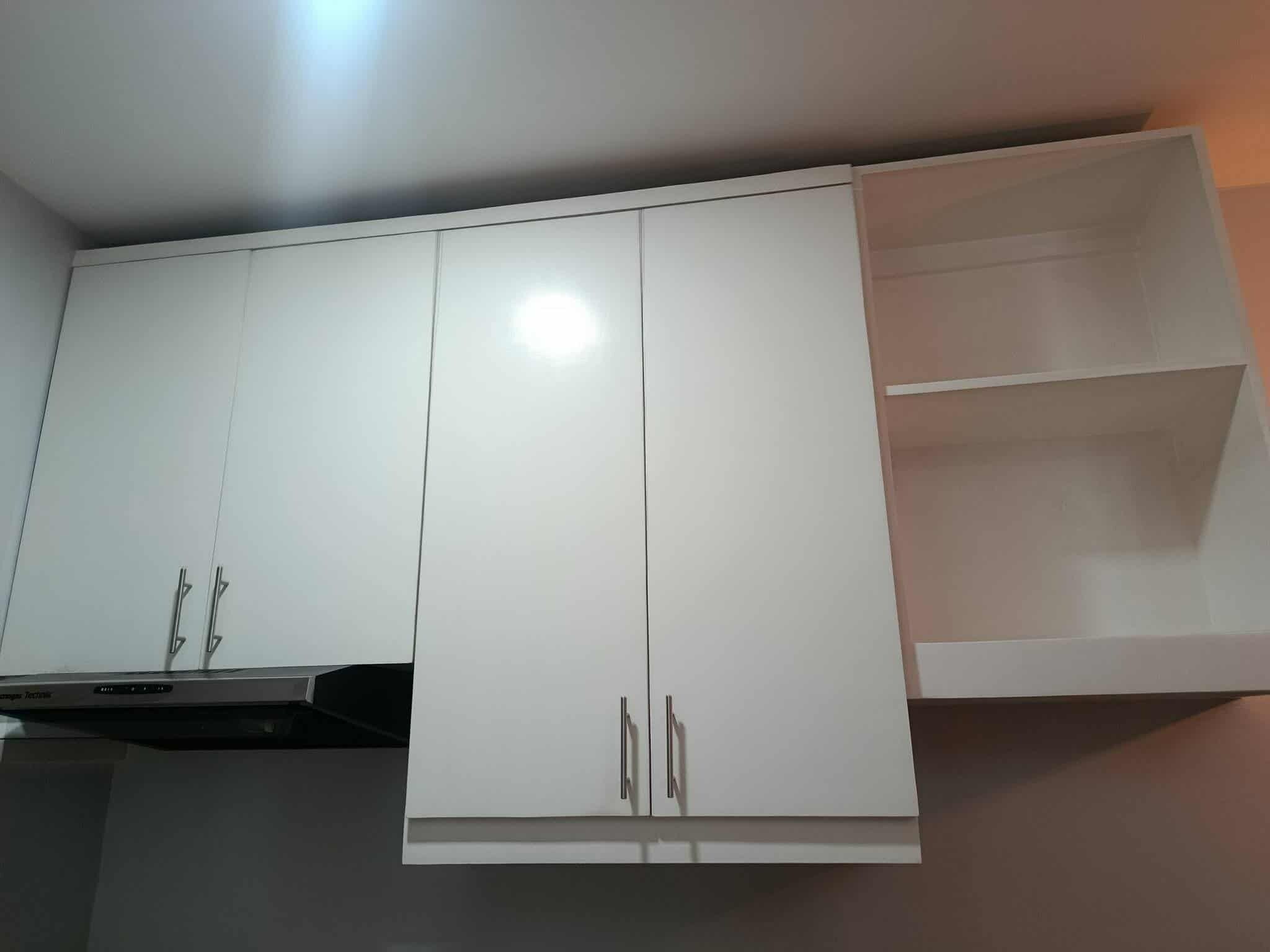 A kitchen with white cabinets, a microwave, and a stove.