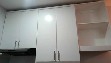 A kitchen with white cabinets, a microwave, and a stove.