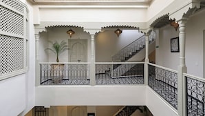 A multi-level interior with ornate railings, a staircase, and a potted plant. - Riad Della (Marrakech)